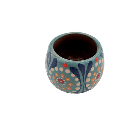 Small ceramic cup with floral patterns on a white background