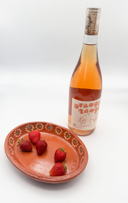 Bottle of rose wine with a plate of strawberries on a white background
