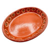 Terracotta dish with decorative patterns on a white background