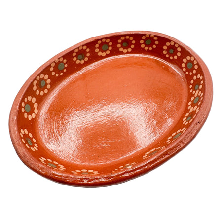 Terracotta dish with decorative patterns on a white background