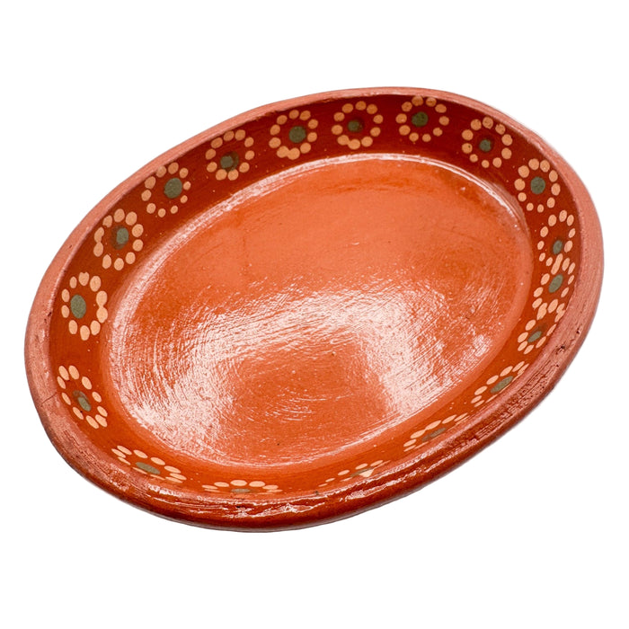 Terracotta dish with decorative patterns on a white background