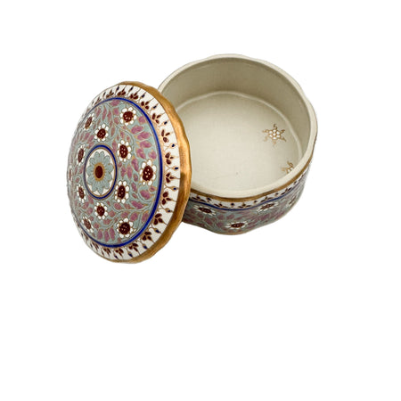 Decorative ceramic box with intricate patterns on a white background