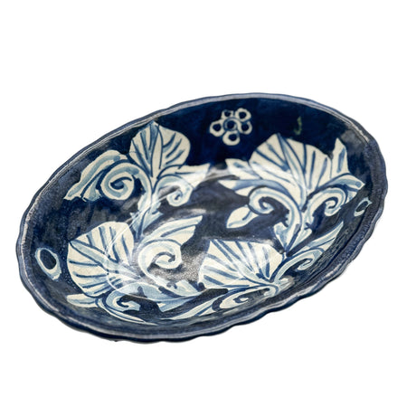 Blue and white ceramic dish with floral patterns on a white background