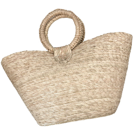 Woven straw tote bag with round handles on a light gray background